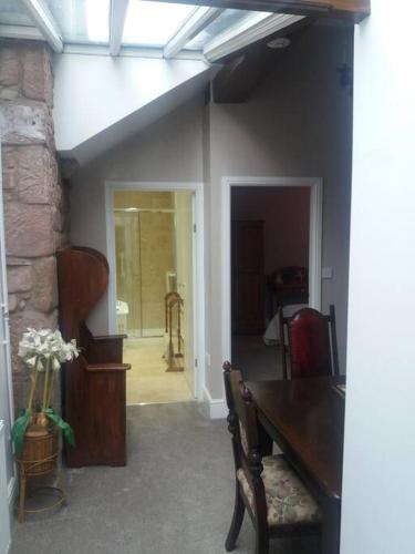 a dining room with a table and a stone wall at The Jewel in the Crown, countryside escape in Rushton Spencer