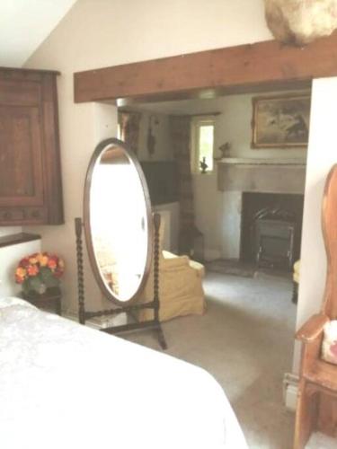 a mirror in a living room with a fireplace at The Jewel in the Crown, countryside escape in Rushton Spencer