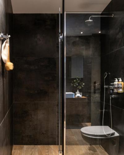 a bathroom with a glass shower with a toilet at Play Theatrou Athens in Athens