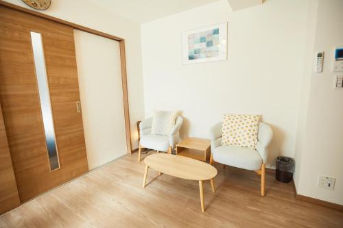 a room with two chairs and a table and a door at SG Premium KASAI in Tokyo