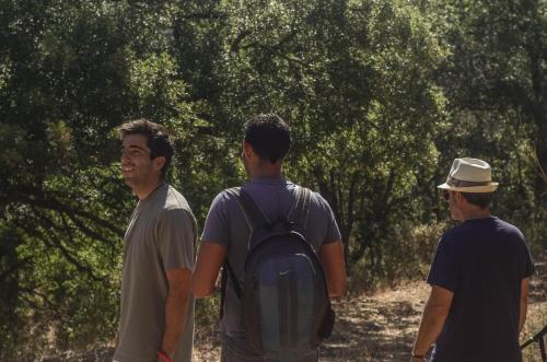 a group of three men walking down a trail at La Dehesa de Don Pedro in Monesterio