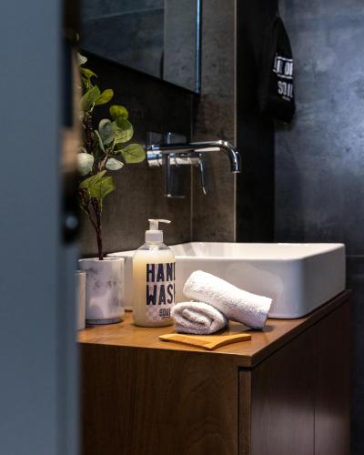 a bathroom sink with a bottle of hair mass at Play Theatrou Athens in Athens