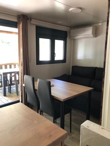a living room with a table and a couch at Càmping Molí de Vilamala in Les Planes d'Hostoles