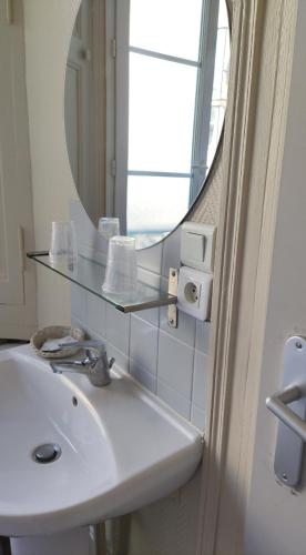 a bathroom with a sink and a mirror at Le Nid - Studios in Chartres