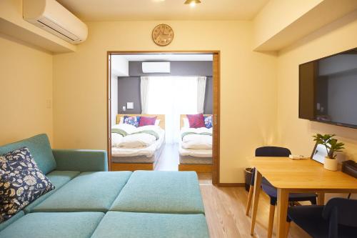 a living room with a couch and a tv at SG Premium KASAI in Tokyo