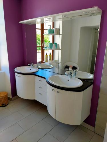 une salle de bain avec deux lavabos et un miroir dans l'établissement Magnifique appartement en centre ville de château chinon ville, à Château-Chinon