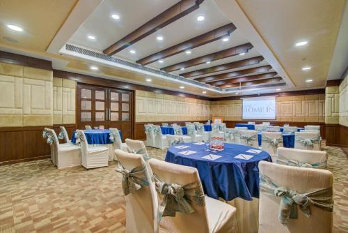 a banquet hall with a blue table and chairs at Hotel Home In By Amrik Sukhdev in Sonīpat