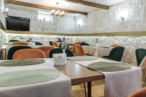 een eetkamer met tafels en stoelen en een tv bij Hotel Velyka Vedmedytsya in Jaremtsje