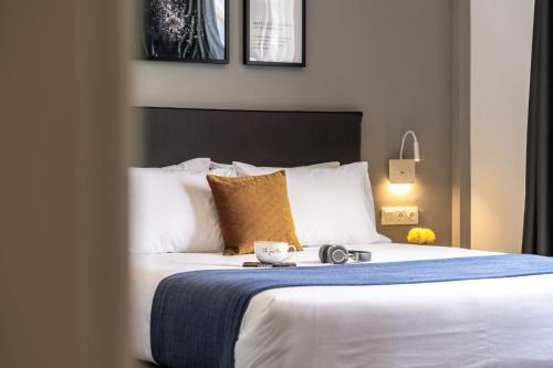 a hotel room with a large bed with a bowl on it at Play Theatrou Athens in Athens