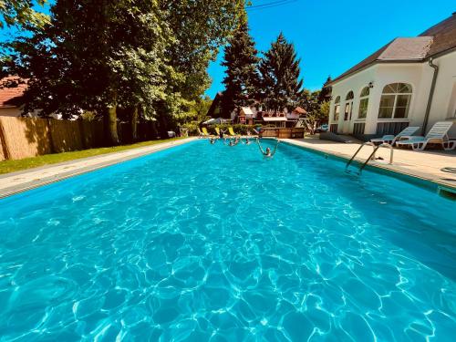 una gran piscina azul en una casa en Sommer Panzió, en Balatonföldvár