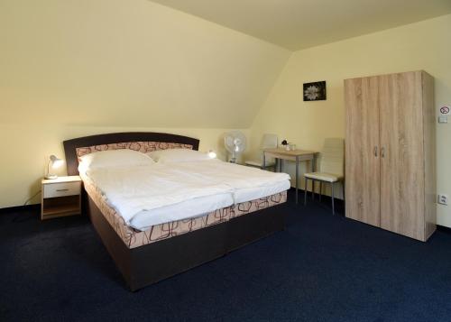 1 dormitorio con 1 cama grande y 2 mesitas de noche en Hotel U Jezírka, en Liberec