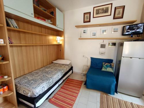 a small room with a bed and a refrigerator at App Casa Dei Pini - Bilocale in Capoliveri