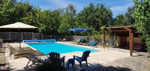 une piscine avec des chaises et un parasol dans l'établissement MAS LE CORBERY, à Largentière