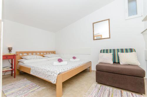 ein Schlafzimmer mit einem Bett und einem Stuhl in der Unterkunft House Branimir in Kolan