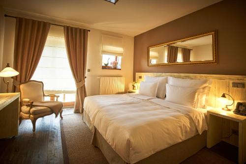 a hotel room with a large bed and a chair at Resort Čapí Hnízdo in Olbramovice Ves