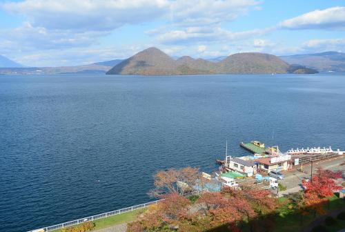
a large body of water with a lighthouse at Toya Kanko Hotel in Lake Toya
