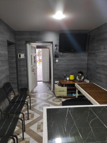 a living room with a television and a table and chairs at Садиба Герасімових in Kamianets-Podilskyi