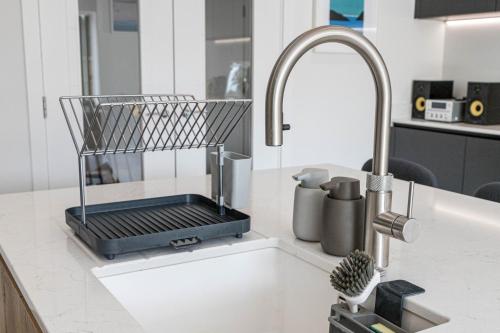 um lavatório de cozinha com um cesto em cima em Brand new, luxury, 4 bed house, 5 mins to Beach - The Laurels em Poole