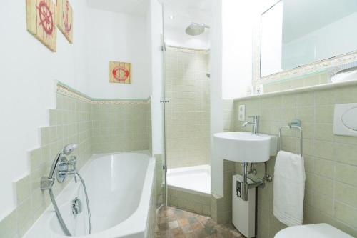 ein Badezimmer mit einer Badewanne, einem Waschbecken und einem WC in der Unterkunft Ferienwohnung Hansen in Westerland