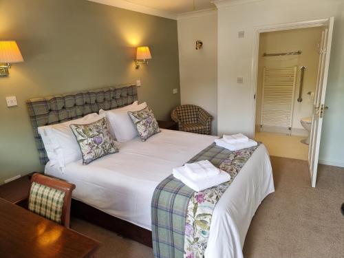 a bedroom with a bed and a chair and a table at The Courthouse Inn in Colchester