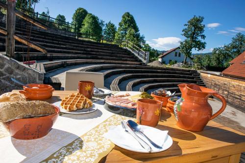 una mesa con comida y jarrones en la parte superior en Youth Hostel Arsviva, en Stari Trg pri Ložu