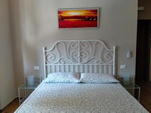 a bed in a bedroom with a picture on the wall at il Cantuccio in Lucca