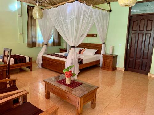 a bedroom with a bed with a canopy at Budi Sun Resort in Maumere