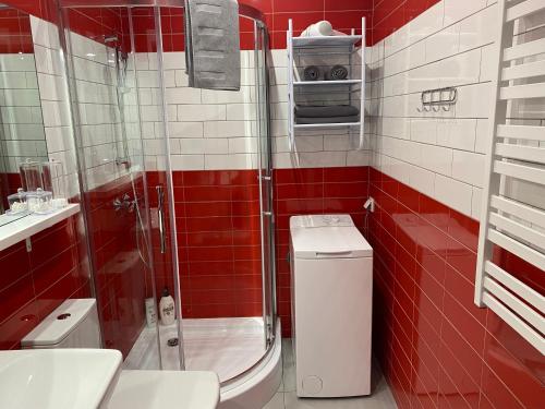 baño de azulejos rojos con aseo y ducha en Apartment II GrayFor2 Old Town Kraków en Cracovia