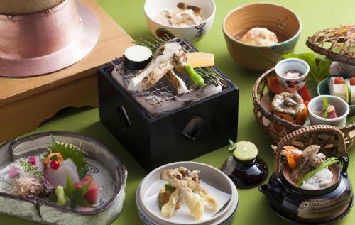 a table topped with plates and bowls of food at Rihga Royal Hotel Hiroshima in Hiroshima