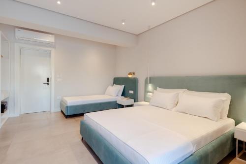 a bedroom with a large white bed and a room with a bed sqor at Artis Blue Relax in Himare