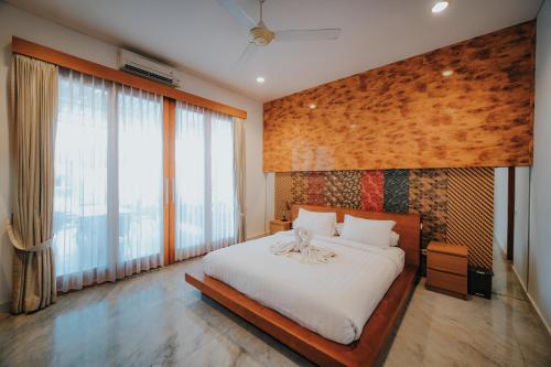 a bedroom with a large bed and large windows at Bali Diamond Estates & Villas in Keramas