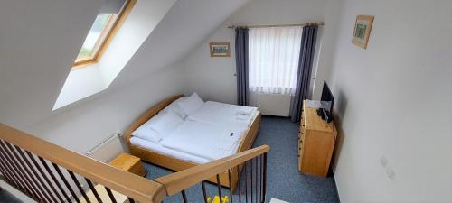 フリンブルクにあるHotel Vltavaのベッドと窓が備わる小さな客室です。