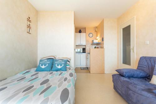 a small bedroom with a bed and a couch at Le Valet in Saint-Cast-le-Guildo
