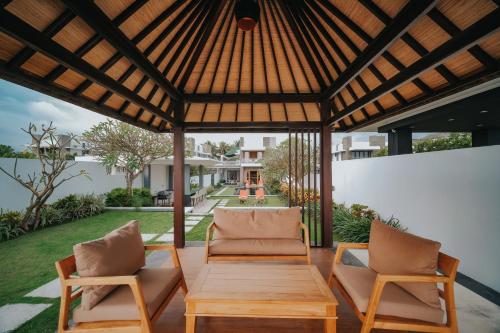a patio with two chairs and a wooden table at Bali Diamond Estates & Villas in Keramas