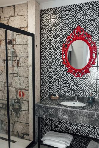 bagno con specchio rosso e lavandino di Chloe hotel Alacati ad Alaçatı
