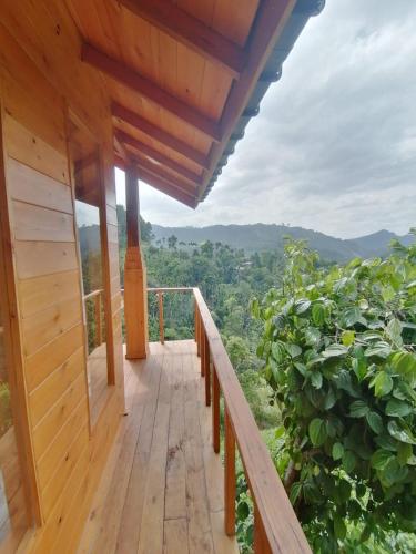 a wooden deck with a view of the mountains at Green Nature Paradise Ella in Ella