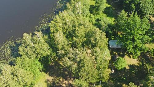 an aerial view of a house in the trees next to a river at Duriu sodyba in Molėtai