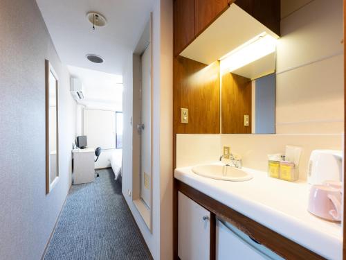 ein Bad mit einem Waschbecken und einem Spiegel in der Unterkunft Tabist Urban Stays Asakusa in Tokio