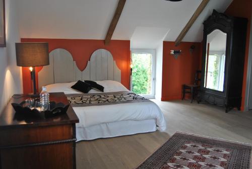 a bedroom with a bed and a dresser and a mirror at Ker Liviou in Lancieux