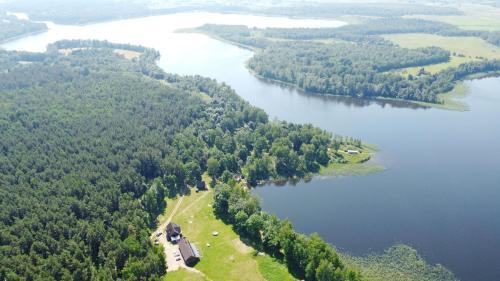 an aerial view of a lake with trees and a house at Duriu sodyba in Molėtai