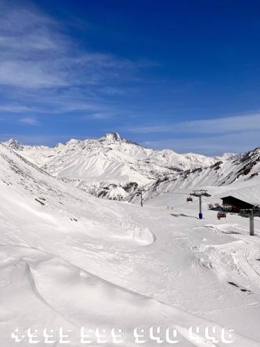 a snow covered mountain with a ski lodge in the distance at Studio Apartment NFT New Gudauri 215 in Gudauri