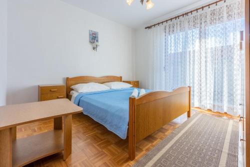 a bedroom with a bed and a large window at Apartments Josip in Novi Vinodolski