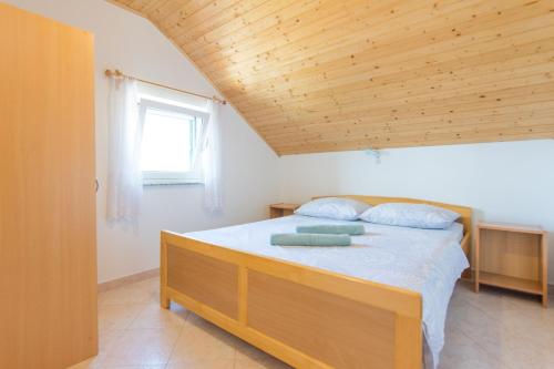 - une chambre avec un lit et un plafond en bois dans l'établissement House Motar, à Ždrelac