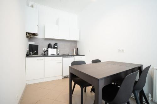 a kitchen with a black table and chairs at Lovely 2-bedroom apartment next to Praterstern in Vienna