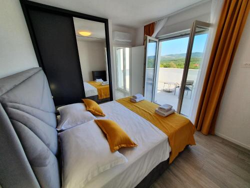 a bedroom with a large bed with a large window at Little Getaway in Veliki Broćanac