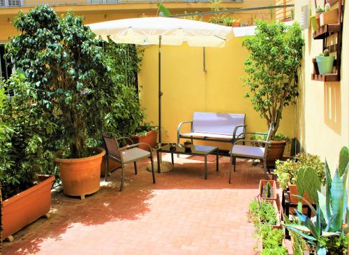 un patio con tavolo, sedie e piante di Di affreschi e volte a Napoli