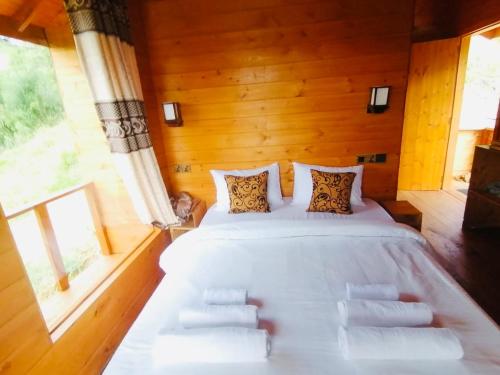a bedroom with a large white bed with two windows at Green Nature Paradise Ella in Ella