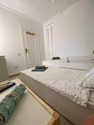 a white bedroom with a bed and a desk at Apartamento Nuevo MannA in Oropesa del Mar