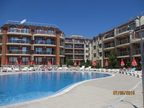 a swimming pool in front of some apartment buildings at Ravda Sun Sea Ressort 2 in Ravda