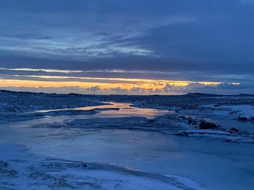 a view of a river with snow on the ground at Álftártunga Farm Guesthouse in Borgarnes